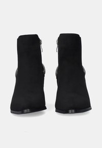 Botines de ante negro con una textura suave, punta redondeada y acentos decorativos en plata a los lados. Presentan un cierre de cremallera.