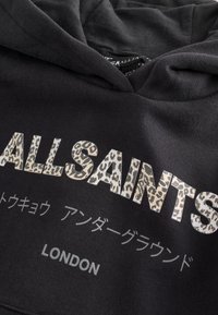 Sweat à capuche noir avec "ALLSAINTS" en imprimé léopard, caractères japonais en dessous et le mot "LONDON" imprimé en dessous.