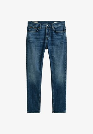 Dunkelblaue Denim-Jeans mit Vorderentaschen, Gürtelschlaufen und Knopfverschluss, zeigen leichte Verfärbungen an Oberschenkeln und Knien.