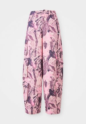Des pantalons larges à motifs roses et violets présentent un design de feuilles et de branches, avec une taille haute et des poches latérales pour une fonctionnalité supplémentaire.