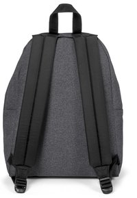 Mochila de tela gris con correas negras, con una superficie texturizada y costuras resistentes. Incluye un asa en la parte superior para llevar.