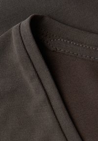 Kurzärmliges braunes T-Shirt mit einer weichen Textur, ausgestattet mit einem glatten Ausschnitt und genähtem Saum, der sein lässiges Design unterstreicht.