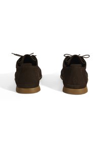 Chaussures en daim marron avec un bout arrondi, un laçage et une semelle en caoutchouc beige. Présentent des accents de couture et un talon texturé.