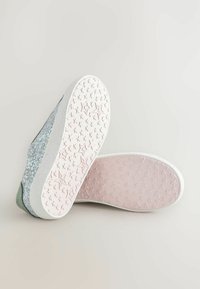 Glitzernde blaue und grüne Sneakers mit weißen Sohlen, die eine sternmusternde rosa Unterseite aufweisen. Glatte Textur mit einem glänzenden Finish an den Seiten.