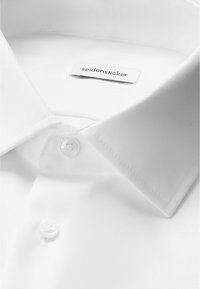 Weißes Hemd mit spitzem Kragen, zwei Knöpfen geschlossen und einem "seidensticker" Markenlabel im Kragen.