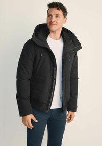 Czarna pikowana kurtka z kapturem, zapięcie na zamek błyskawiczny i wieloma kieszeniami. Ozdobiona niebieskimi akcentami i ściągaczem na dole.