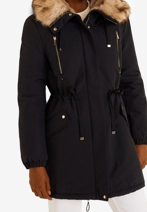 Parka d'hiver noire avec capuche bordée de fourrure, fermeture éclair frontale, taille à cordon, poches poitrine zippées et poches à rabat sur les hanches.