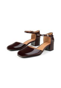 Chaussures en cuir verni bordeaux à talon bloc, avec une lanière au niveau de la cheville, un design à bout carré et une semelle intérieure beige. Texture lisse avec une finition brillante.