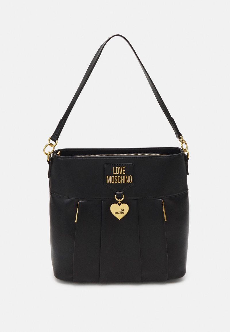 Sac à main noir avec une seule bandoulière, des fermetures éclair dorées et un charme doré en forme de cœur avec le texte "Love Moschino" sur le devant.