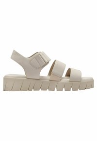 Sandales ouvertes beige avec trois sangles ajustables et semelle crantée épaisse. Fabriquées en matériau synthétique lisse avec une finition mate.