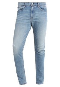 Ljusblå denimjeans med slim fit, med blekta områden och slitna knädetaljer. Standard femficksdesign och metallknappsstängning.