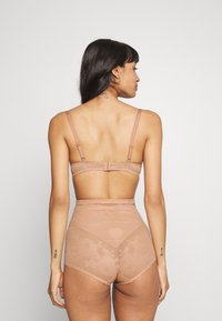 Conjunto de bralette de encaje color marrón claro y ropa interior de cintura alta con estampado floral. Tirantes ajustables y tela suave semitranslúcida.