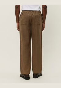 Brune linned bukser med bred benvidde, elastisk talje, to baglommer og en mat finish, der tilbyder en afslappet og åndbar pasform.