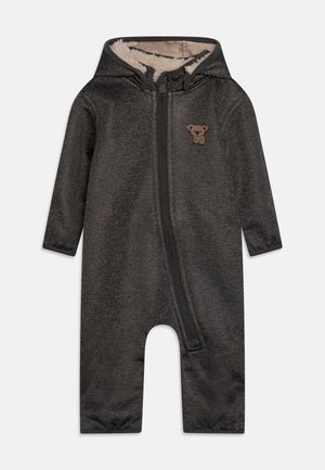 Dark gray onesie with a front zipper, long sleeves, hood, and a soft fleece lining. Features a brown bear applique on the chest.