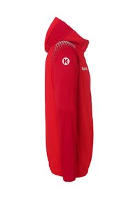 Rode capuchonjack gemaakt van gladde stof, met een iets taps toelopende vorm, logo-accenten op de schouders en textuurdetails op de mouwen.