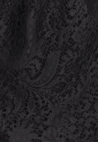 Tessuto di pizzo nero con intricati motivi a spirale, che presenta un mix di aree solide e trasparenti, una consistenza morbida e un aspetto delicato.