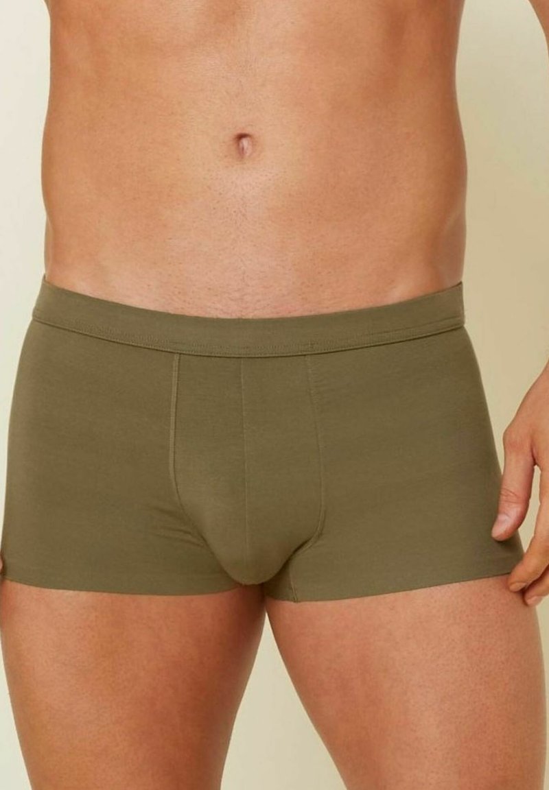 Gröna bomullsboxershorts med en åtsittande design, som har en sömlös midja och en mjuk, slät textur. Enkla och mångsidiga.