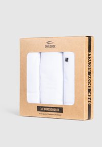 Boxer in bianco in un packaging trasparente. Scatola di cartone con esterno marrone, presenta il nome del marchio, i dettagli del prodotto e la taglia "M".