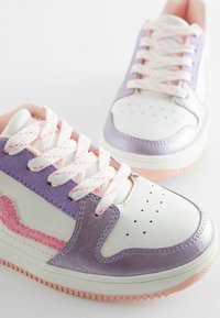 Weiße und pastelllila Sneaker mit pinken Akzenten. Sie verfügen über strukturiertes Leder, eine perforierte Zehenpartie und strukturierte Sohlen mit gemusterten Schnürsenkeln.