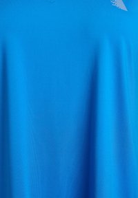 Blaues kurzärmeliges Oberteil aus glattem Stoff mit einem dezenten V-Ausschnitt und einem strukturierten Muster im Brustbereich.