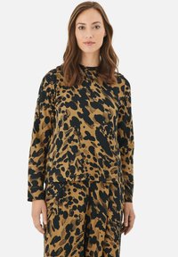 Langærmet top i tan med sort abstrakt leopardprint. Blød, glat stof med en afslappet pasform og rund halsudskæring.