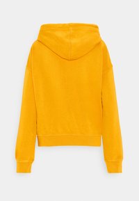 Sudadera amarilla con una textura suave, bolsillo canguro y capucha. Puños y dobladillo acanalados, con un ajuste relajado y un diseño sencillo.