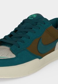 Χαμηλής κοψίματος sneaker Nike SB με άνω μέρος από πετρόλ σουέτ και καφέ ύφασμα, πετρόλ κορδόνια και εκρού υφασμένη σόλα.