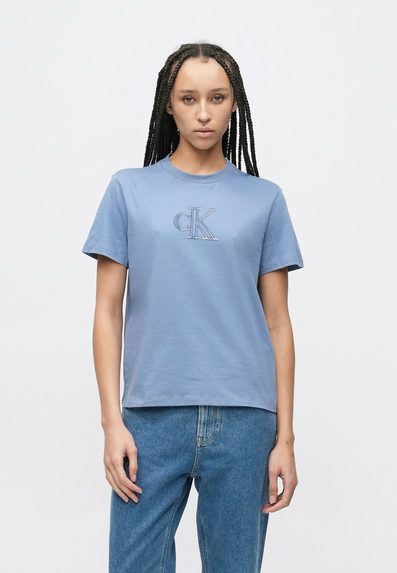 Lys blå bomulls-T-skjorte med korte ermer og rund hals. Har en liten brodert "cK"-logo på brystet. Klassisk passform.