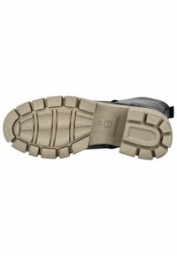 Bota negra con un upper texturizado y una suela de goma beige. La suela presenta tacos definidos para mayor tracción e incluye detalles de marca.