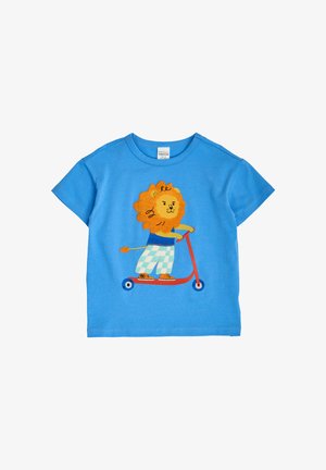 Niebieska dziecięca koszulka z kreskówkowym lwem w kraciastych spodniach i trampkach, jeżdżącym na czerwonym skuterze.