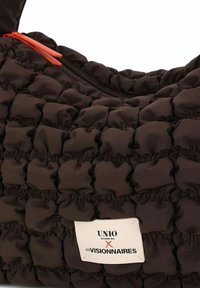 Bruine tasje met gewatteerde stof en een gestructureerd oppervlak. Voorzien van een ritssluiting en een oranje trekkoordje. Label: "UNIO Hamburg x Les Visionnaires."