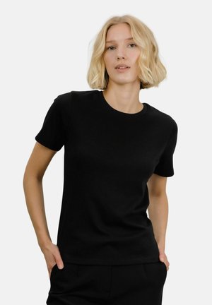Svart T-skjorte med kort erm laget av myk bomull. Har en klassisk rund hals, enkelt design og en tettsittende silhuett.
