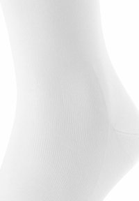 Calzino bianco in cotone con una texture liscia, caratterizzato da un design a coste e aree del tallone e delle punte rinforzate per una maggiore durata.