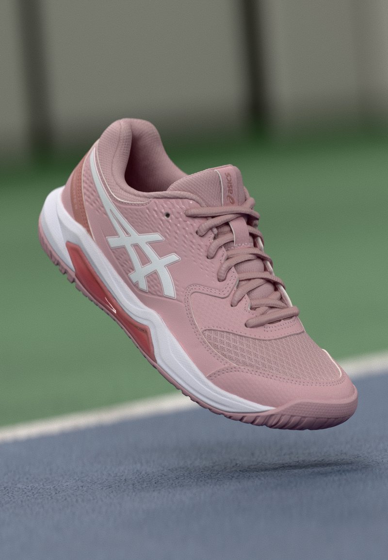 Różowe buty sportowe z teksturowaną siateczkową cholewką, białymi akcentami, pasującymi sznurowadłami oraz widoczną amortyzowaną podeszwą z czerwoną wkładką.