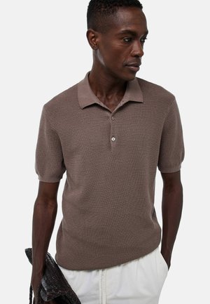 Polo à manches courtes en tricot brun texturé, avec un col doux, une fermeture à trois boutons et une coupe décontractée.
