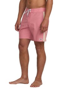 Bañador rosa con una tela texturizada, con un cordón blanco, acentos laterales y un logo en la parte inferior izquierda.