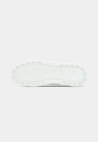 Shoe sole with a textured surface, white color, featuring bicycle graphics around the edges and embossed letters "CPNHGN."