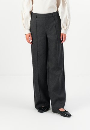Hoch taillierte, weite Hosen aus schiefergrauem Wollmischgewebe mit vorn eingekniffenen Falten und einer glatten Textur. Kombiniert mit schwarzen Ballerinas.
