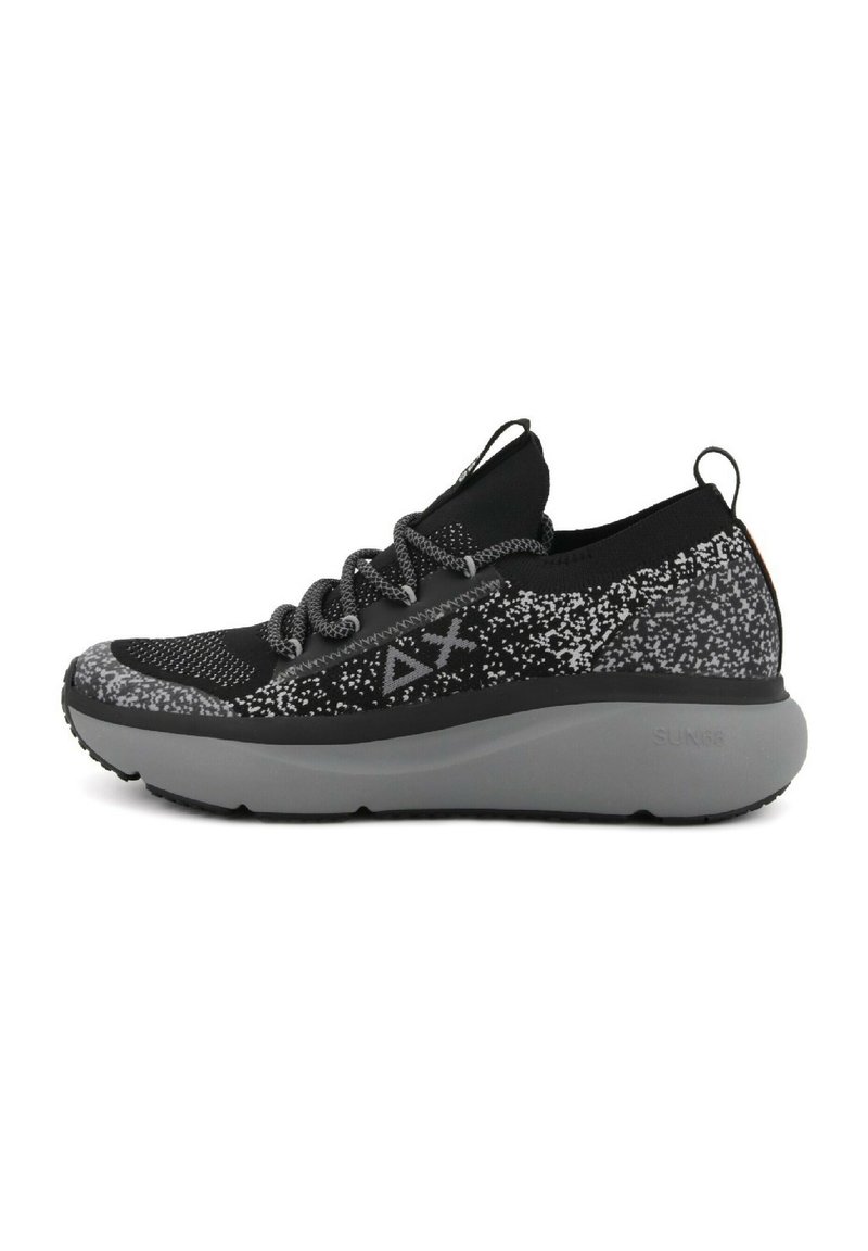 Scarpe sportive nere con una tomaia in maglia texturizzata caratterizzata da un motivo a macchie bianche, suola grigia e linguetta rinforzata per una facile indossatura.