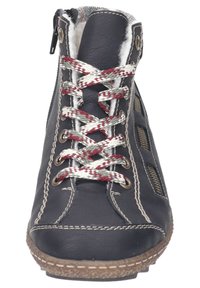 Bota de tobillo de cuero negro con cordones rojos y blancos, forro interior suave, cremalleras laterales y suela de goma texturizada. Presenta acentos de costura ligera.