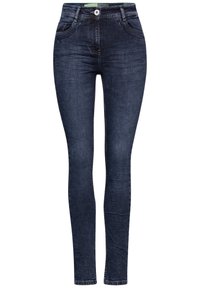 Jean skinny bleu foncé en denim, avec deux poches avant, une fermeture à bouton et des coutures contrastantes le long des coutures.