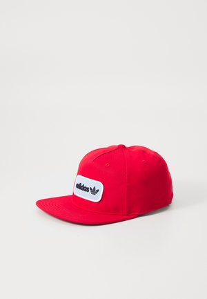 Rød baseballcaps laget av bomull med flat brem, med en hvit lapp som har "adidas"-tekst og logo i svart. Seks-paneldesign, lufthull.