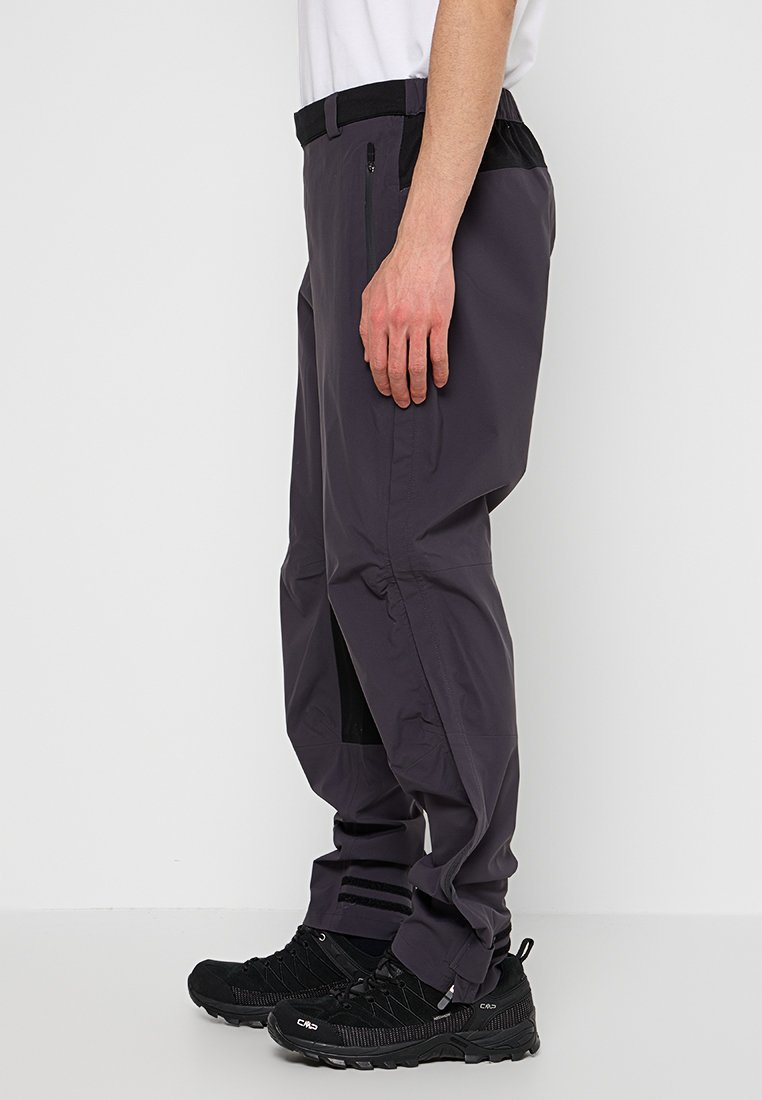Waterdichte wandelbroek in donkergrijs, met ritssluiting zakken, verstelbare tailleband en een losse pasvorm met zwarte accenten en ventilatie.