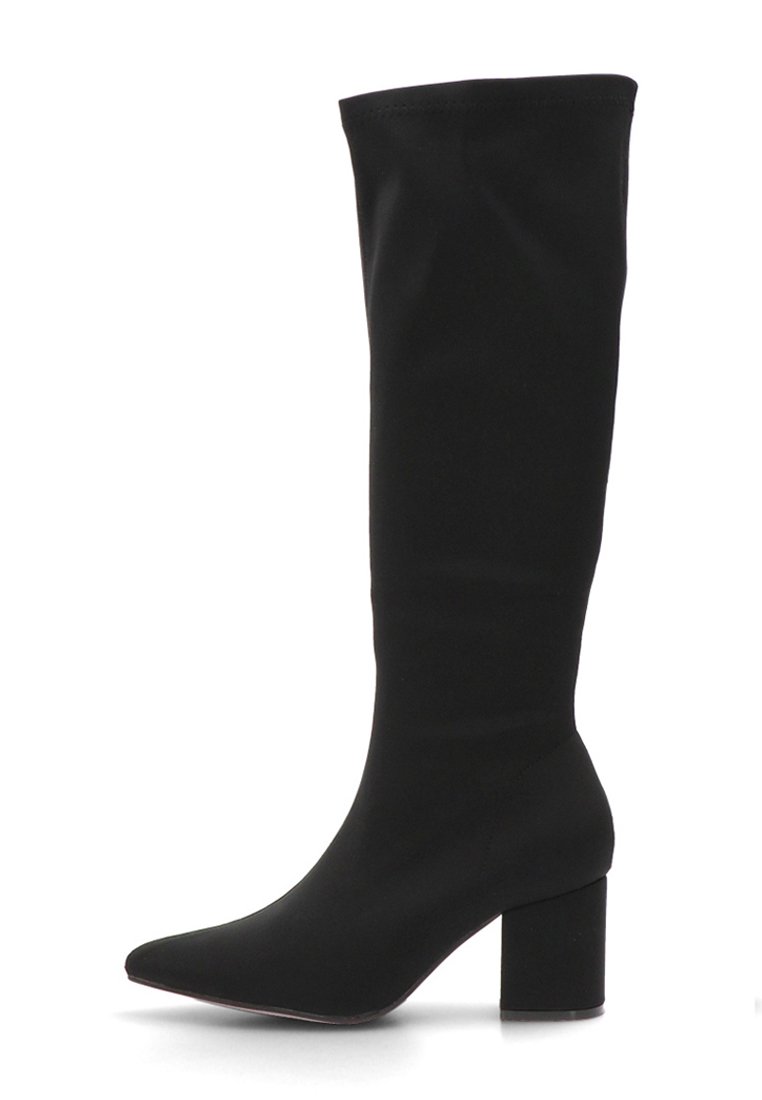 Bota negra hasta la rodilla hecha de material elástico, con punta afilada y tacón cuadrado. Textura suave sin herrajes visibles.