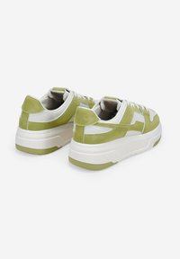 Zapatillas verde y blancas con un diseño de cuero texturizado y ante, que presentan una suela blanca gruesa y acentos laterales en un tono más claro.
