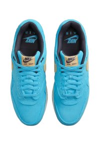 Nike Air Max sneakers featuring a bright blue corduroy upper, contrasting black lining, and a beige branded tongue. Classic lace-up design.