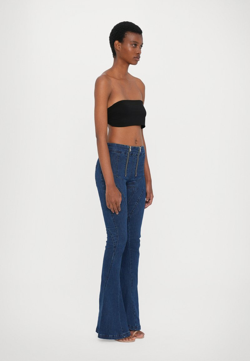 Mörkblå utsvängda jeans med hög midja, med en framdragkedja, böjda sömmar och en mjuk denimtextur. Matchat med en svart strapless topp.