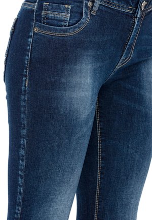 Donkerblauwe denim jeans met lichte vervaging, vijf-vakken ontwerp en dubbel gestikte naden. Voorzien van metalen knoopaccenten.