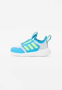 Zapatilla deportiva azul y blanca con parte superior de malla, detalles en verde neón y suela acolchada con lengüetas para facilitar el calzado.