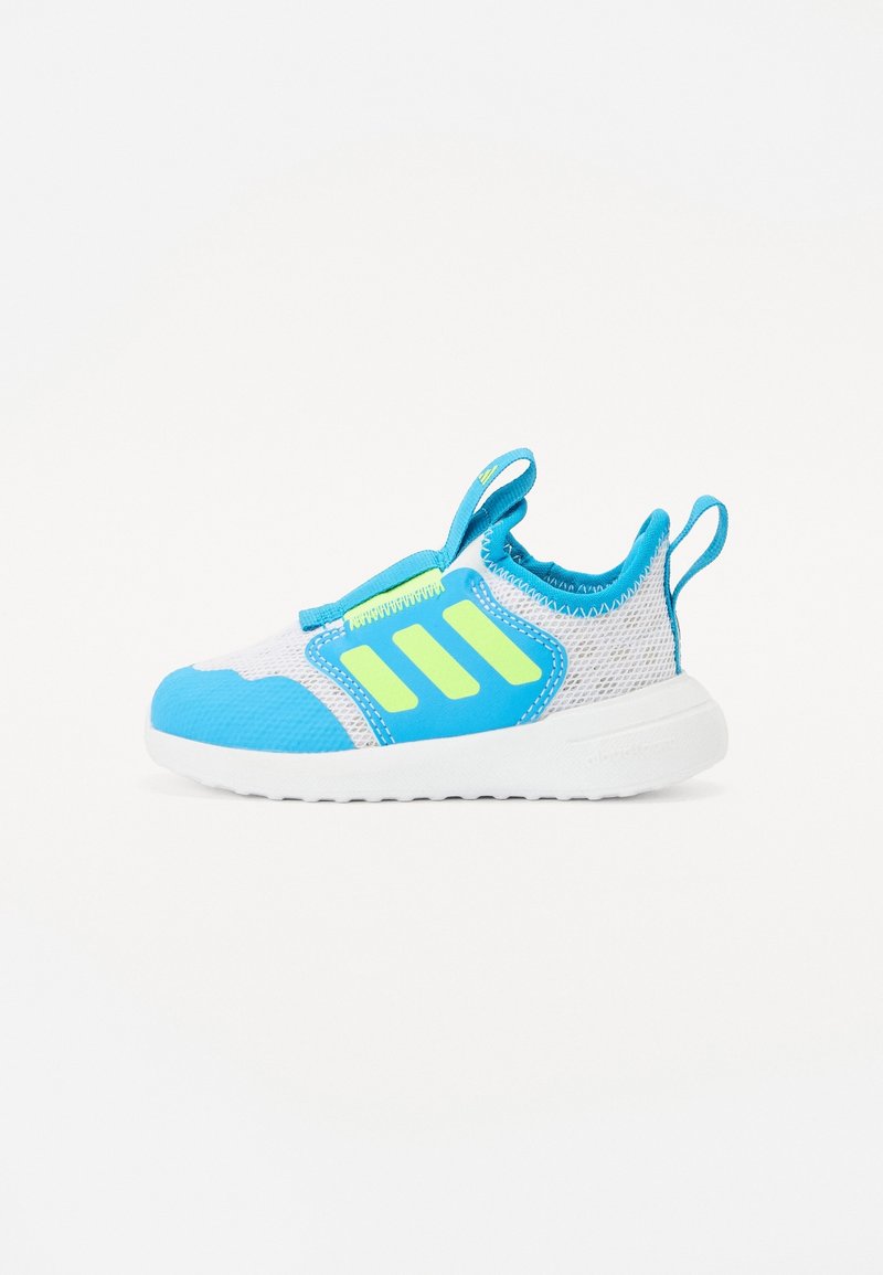 Zapatilla deportiva azul y blanca con parte superior de malla, detalles en verde neón y suela acolchada con lengüetas para facilitar el calzado.
